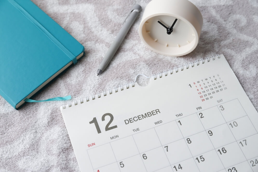 12月のカレンダーとペン、手帳、時計